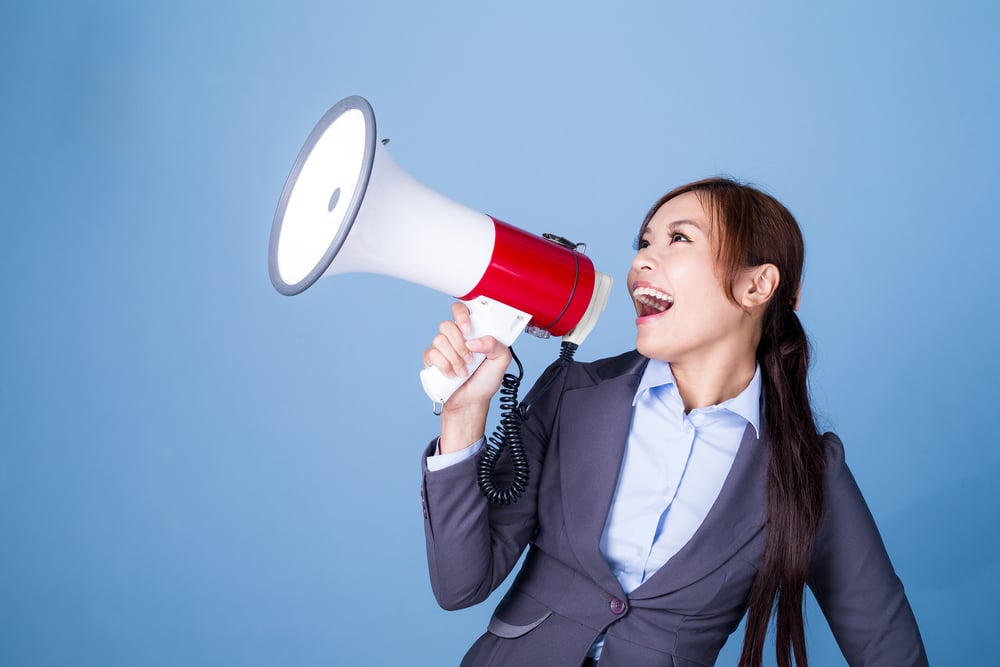 Businesswoman making announcement with megaphone