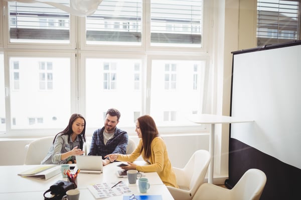 Group of people sitting together at work while discussing something